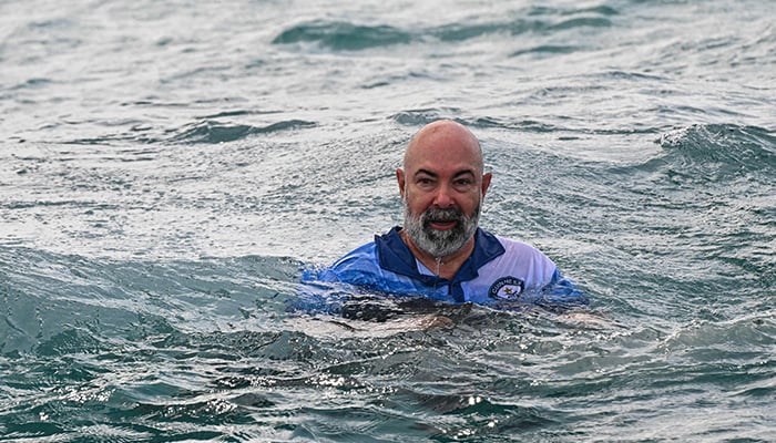 German aerospace engineer Rudiger Koch, 59, jumps into the water to celebrate breaking the Guinness world record for living in the ocean at a depth of eleven meters off the coast of Puerto Lindo, Panama, on January 24, 2025. — AFP