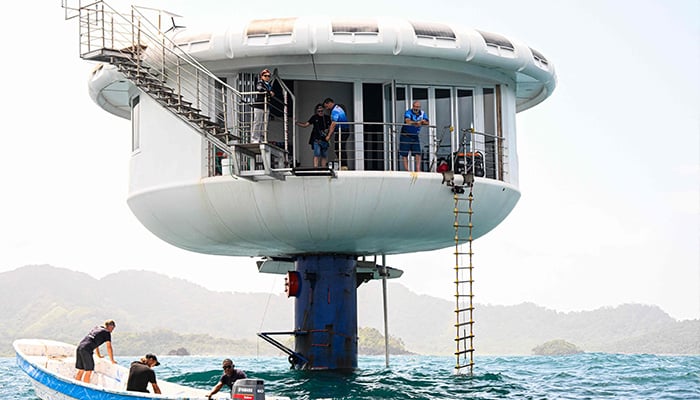 German aerospace engineer Rudiger Koch, 59, (R) stands on the balcony of the seepod after breaking the Guinness world record for living in the ocean at a depth of eleven meters off the coast of Puerto Lindo, Panama, on January 24, 2025. — AFP