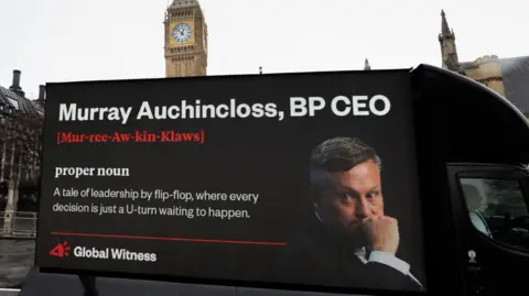 Global Witness An image on a lorry with BP chief executive Murray Auchincloss reading: "A tale of leadership by flip-flop, where every decision is just a U-turn waiting to happen"