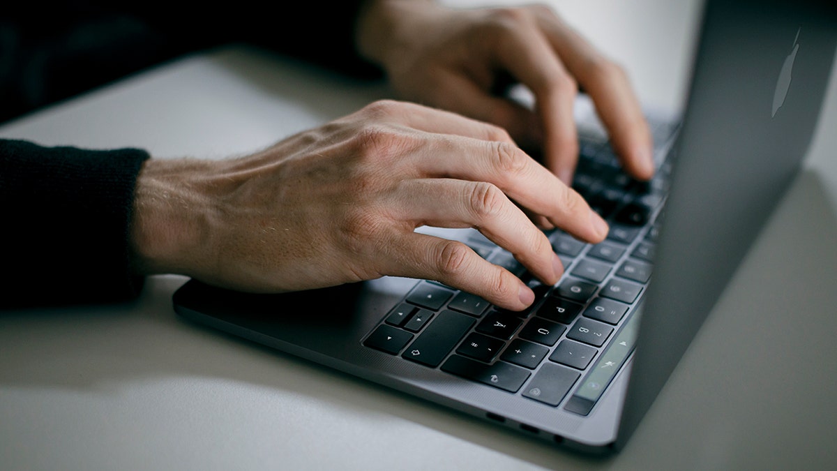 Man typing on his laptop.