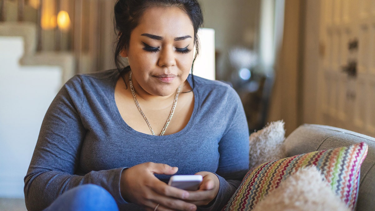 Woman texts on smartphone